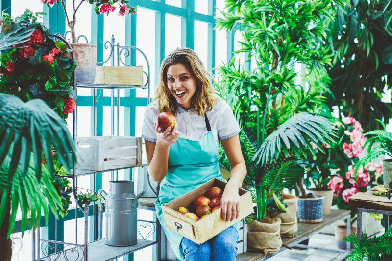 Foto van jonge onderneemster met een kist met appels