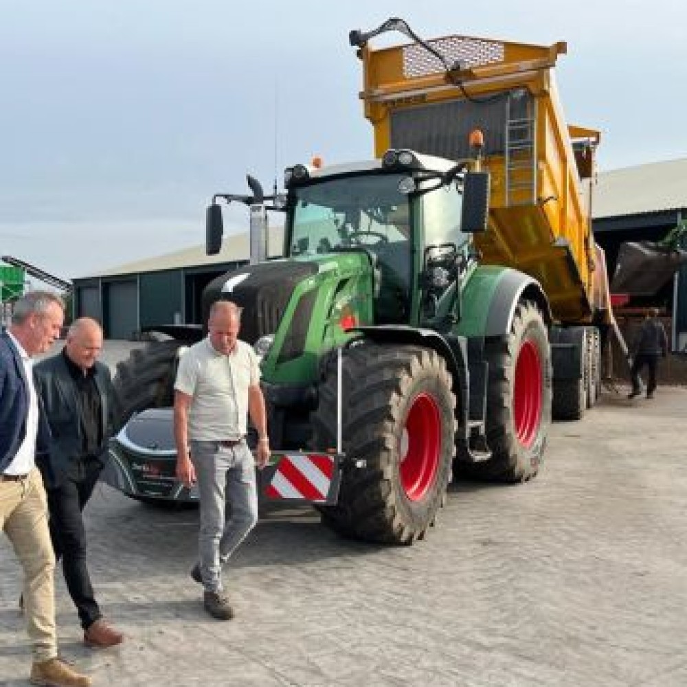 Drie mannen voor een tractor op een boerderij