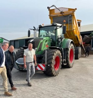Drie mannen voor een tractor op een boerderij