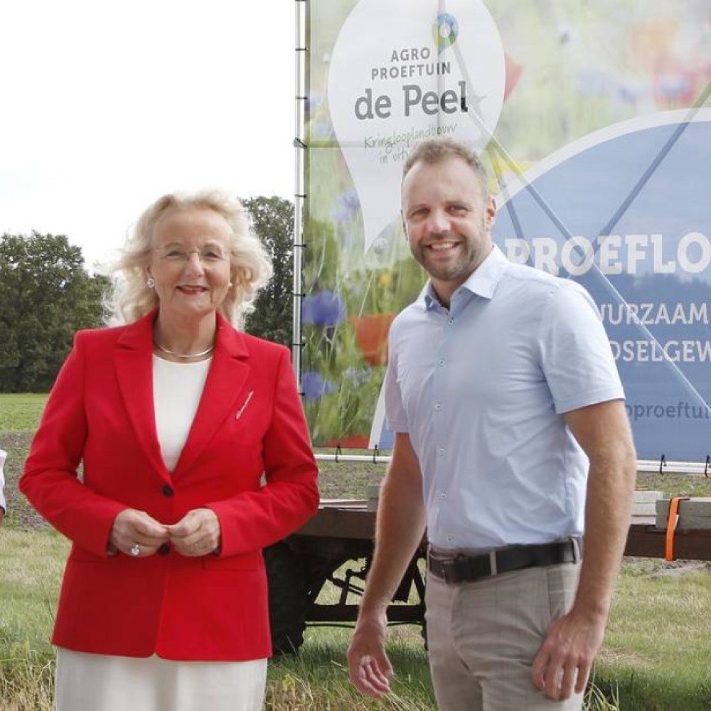 Jeroen van den Heuvel naast de gedeputeerde Landbouw van de provincie Noord-Brabant voor een banner van De AgroProeftuin 