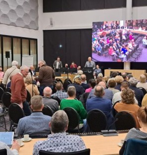 Raadsleden met elkaar in overleg in gemeentehuis Oss