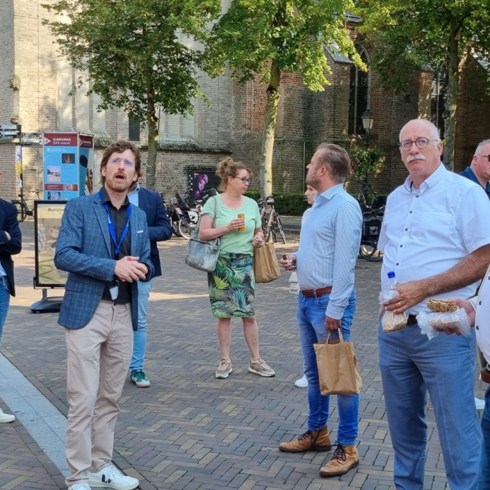 Groep bestuurders staat op een plein vóór een kerk