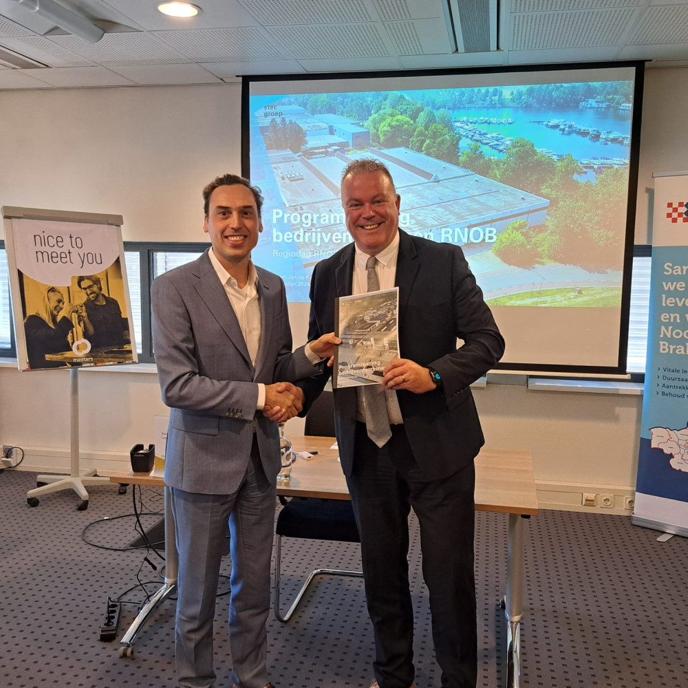 Wethouder Frank den Brok (r) overhandigt de nieuwe programmering bedrijventerreinen RNOB aan gedeputeerde Stijn Smeulders (l).