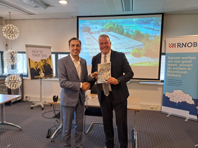 Wethouder Frank den Brok (r) overhandigt de nieuwe programmering bedrijventerreinen RNOB aan gedeputeerde Stijn Smeulders (l).