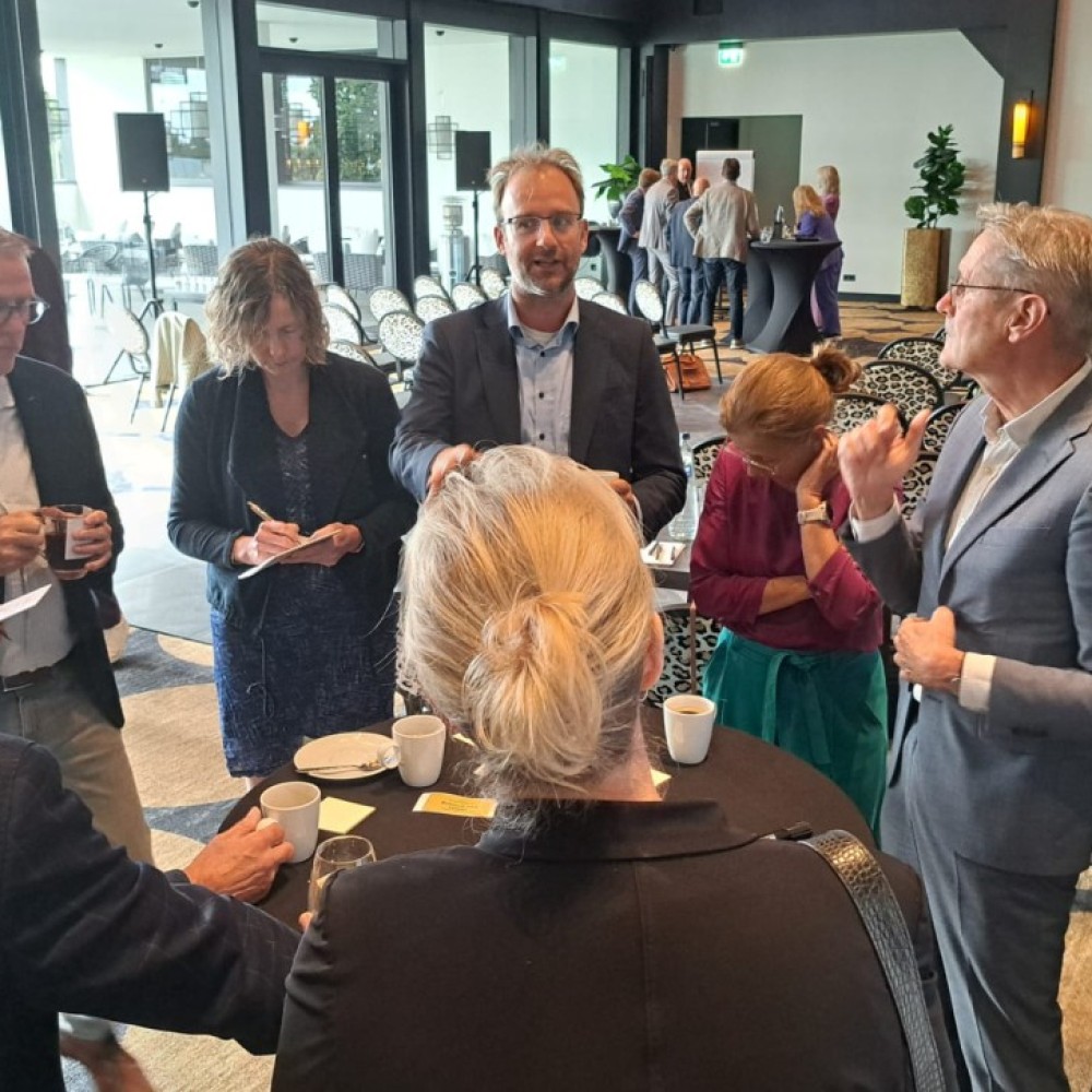 Klein groepje deelnemers bestuurlijke Regioheidag met elkaar in gesprek 