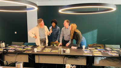 Vier deelnemers aan de wokshop met elkaar in gesprek, staande bij ene tafel