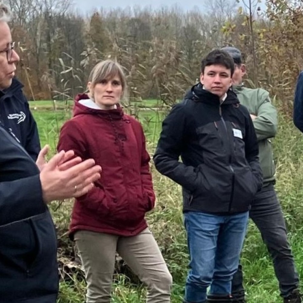 Wethouder Desiré van Laarhoven in gesprek met jonge mensen in een bosrijke omgeving