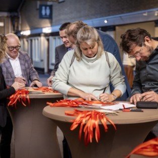 Eenkele deelnemers aan het slotevent schrijven teksten op kaarten