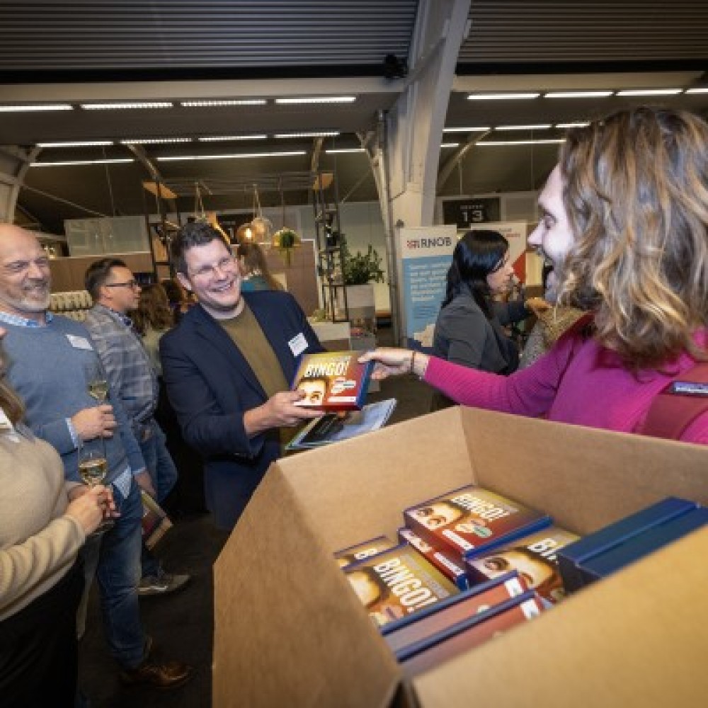 Een dame deelt doosjes uit aan deelnemers van het Regio Deal slotevent