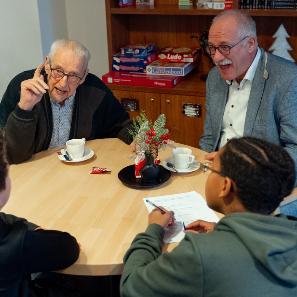 Wethouder Maarten Jilisen in gesprek met twee kinderen van SBO Palet en een bewoner van verzorgingstehuis Symfonie.