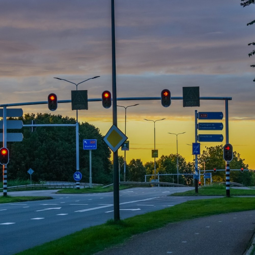 Kruispunt met stoplichten zonder verkeer in de avondschemering