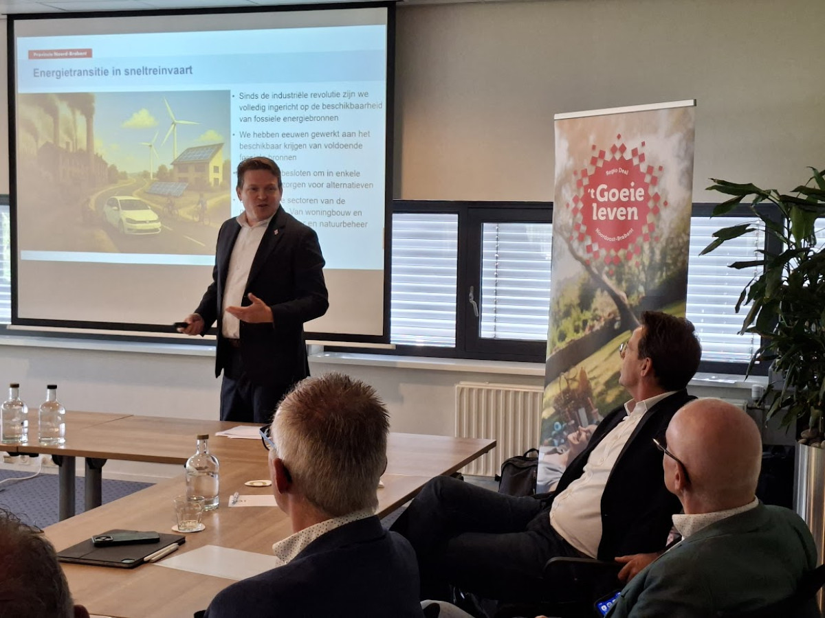 Bas Maes, Brabantse gedeputeerde van Klimaat en Energie, geeft een presentatie over netcongestie in een zaal vol wethouders.