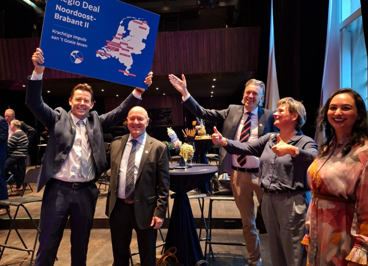 Kleine groep blije mensen waarvan één persoon een bord van Regio Deal 't Goeie leven omhoog houdt 