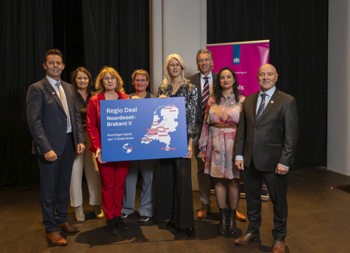 Groep mensen die samen poseren met een bord van de Regio Deal Noordoost-Brabant tijdens de officiële Regio Deal startbijeenkomst