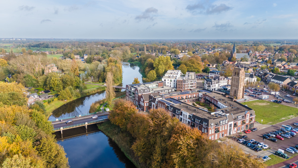 Luchtfoto van het groene en waterrijke historisch centrum van Sint-Michielsgestel met brug en omliggende woonwijken.