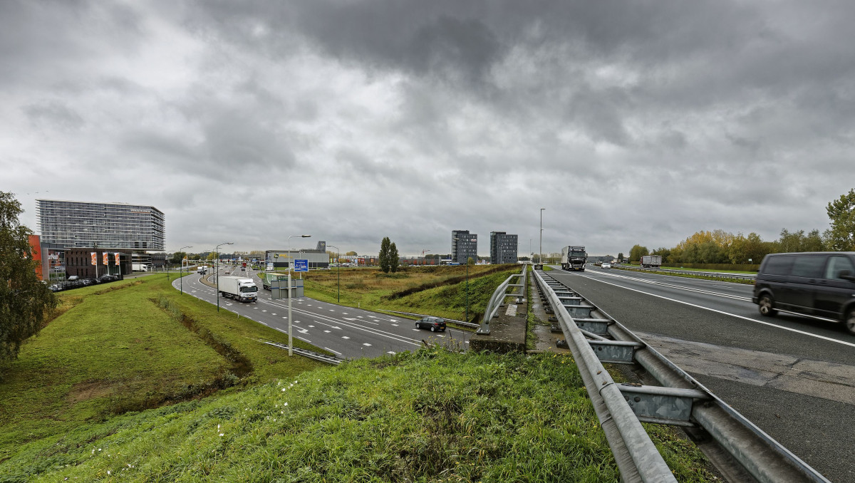 Stedelijk verkeersknooppunt met snelweg A50, afslag en moderne kantoorgebouwen onder bewolkte lucht