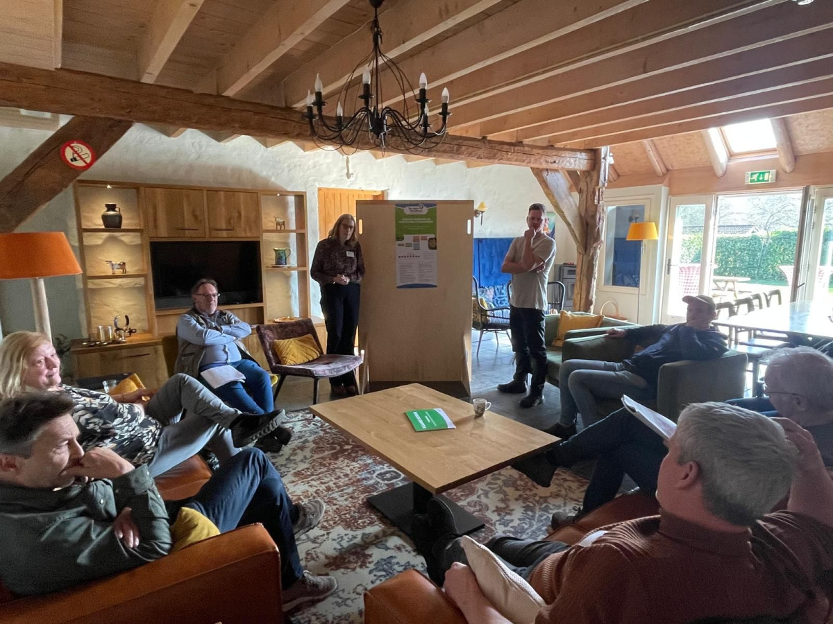 Themasessie tijdens de kennisbijeenkomst in een landelijke vergaderruimte waar deelnemers een presentatie bespreken.