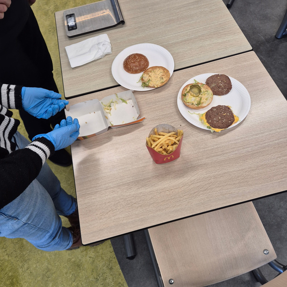 Leerlingen analyseren een hamburger en frietjes tijdens praktijkles voeding.
