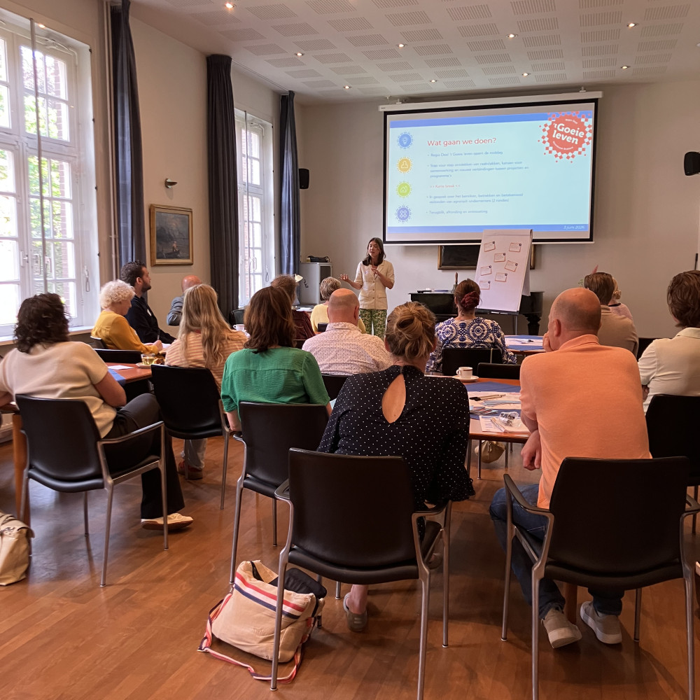 Presentatie door een spreker voor de deelnemers van de bijeenkomst over agrarisch onderemersschap een groot scherm