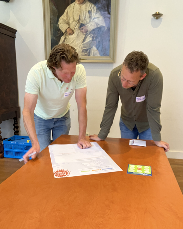 Twee deelnemers werken samen aan een opdracht tijdens de bijeenkomst over agrarisch ondernemerschap.