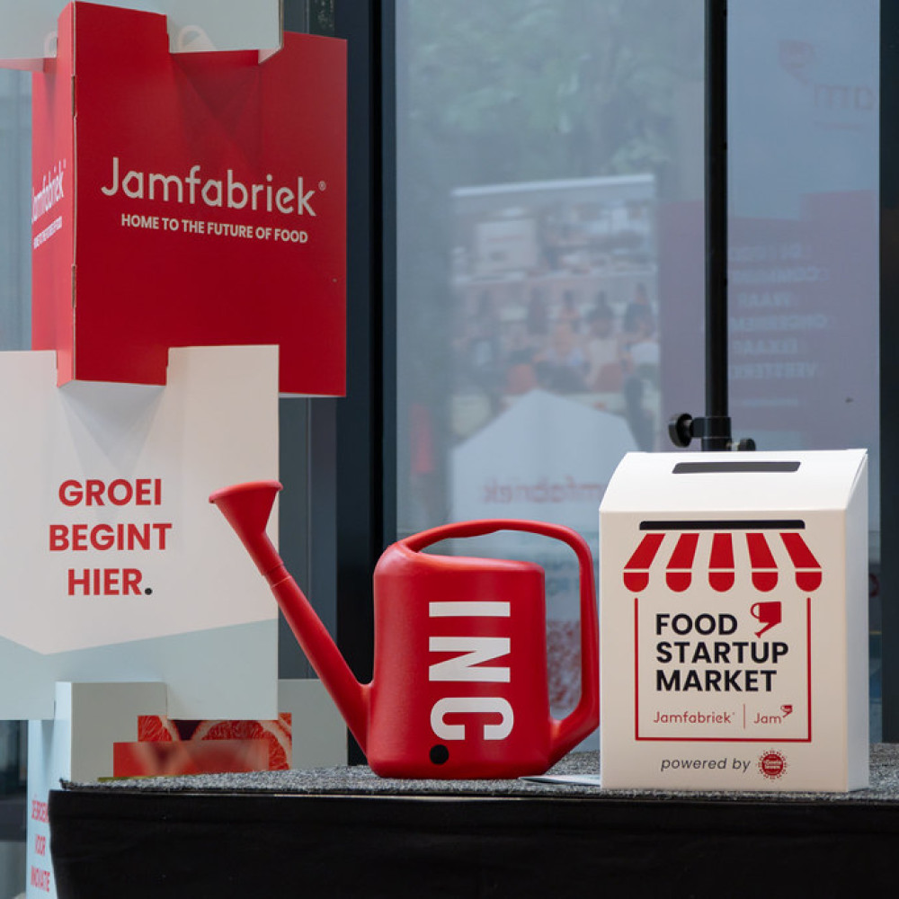 Promotiemateriaal van de Food Startup Market in de Jamfabriek met gieter, beursstand en brievenbus in de kleuren van Jamfabriek.