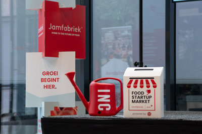 Promotiemateriaal van de Food Startup Market in de Jamfabriek met gieter, beursstand en brievenbus in de kleuren van Jamfabriek.