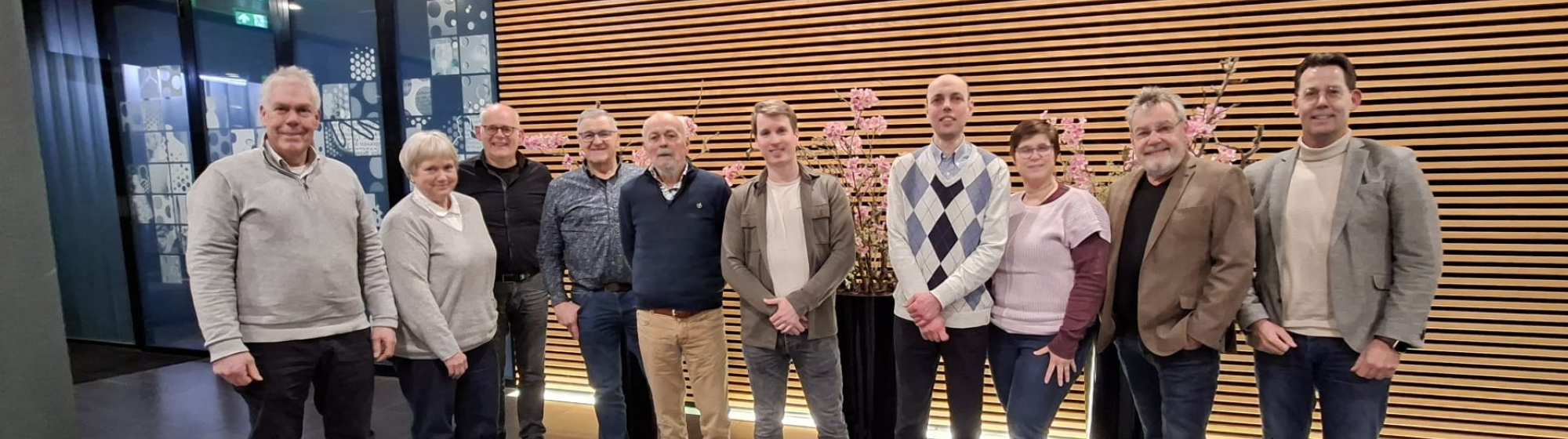 De leden van de Klankbordgroep raadsleden staan naast elkaar op een rij met een houten wand op de achtergrond