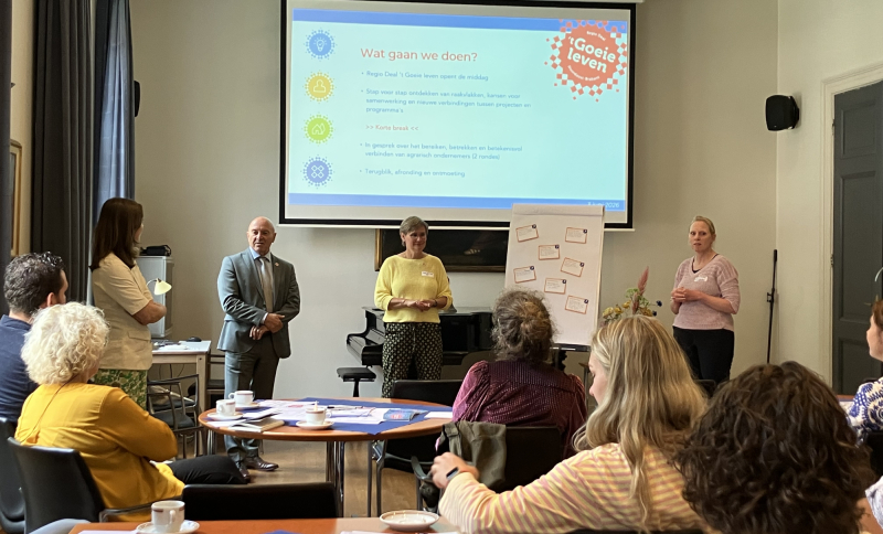 Presentatie door dre personen met groot scherm tijdens crossoverbijeenkomst over agrarisch ondernemerschap voor de deelnemers en flip-over