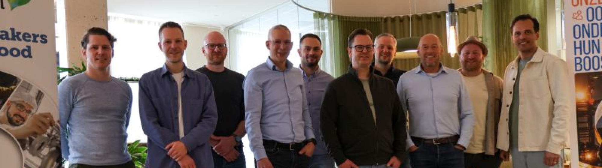 Groepsfoto van de 10 ondernemers van MKB Boost op een rij naast een rollup banner van AgriFood Capital