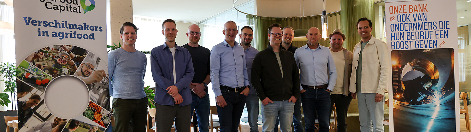 Groepsfoto van de 10 ondernemers van de pilot van MKB Boost naast een rollup banner van AgriFood Capital