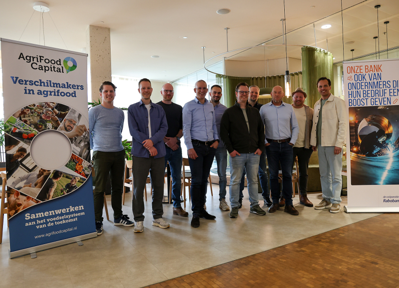 Groepsfoto van de 10 ondernemers van de pilot van MKB Boost naast een rollup banner van AgriFood Capital