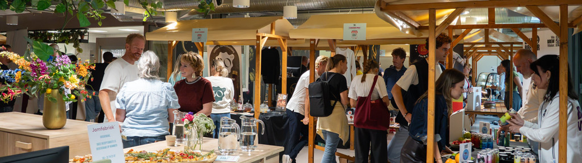 Bezoekers ontmoeten innovatieve foodondernemers tijdens de Food Startup Market in de Jamfabriek, een evenement gericht op duurzame voeding, streekproducten en voedselinnovatie.