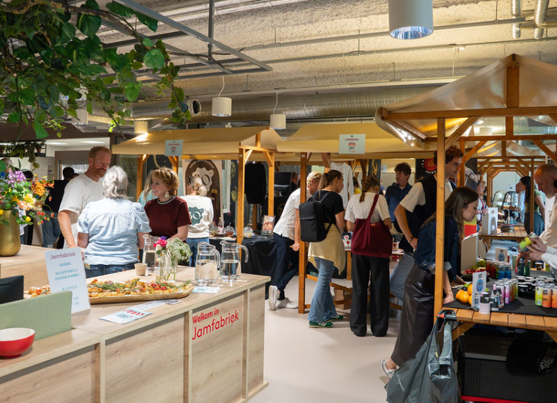 Bezoekers ontmoeten innovatieve foodondernemers tijdens de Food Startup Market in de Jamfabriek, een evenement gericht op duurzame voeding, streekproducten en voedselinnovatie.