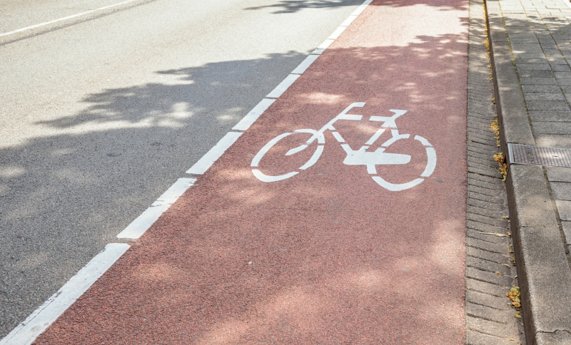 Close-up van een snelfietspad langs een doorgaande weg.
