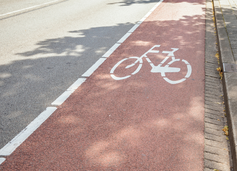 Close-up van een snelfietspad langs een doorgaande weg.