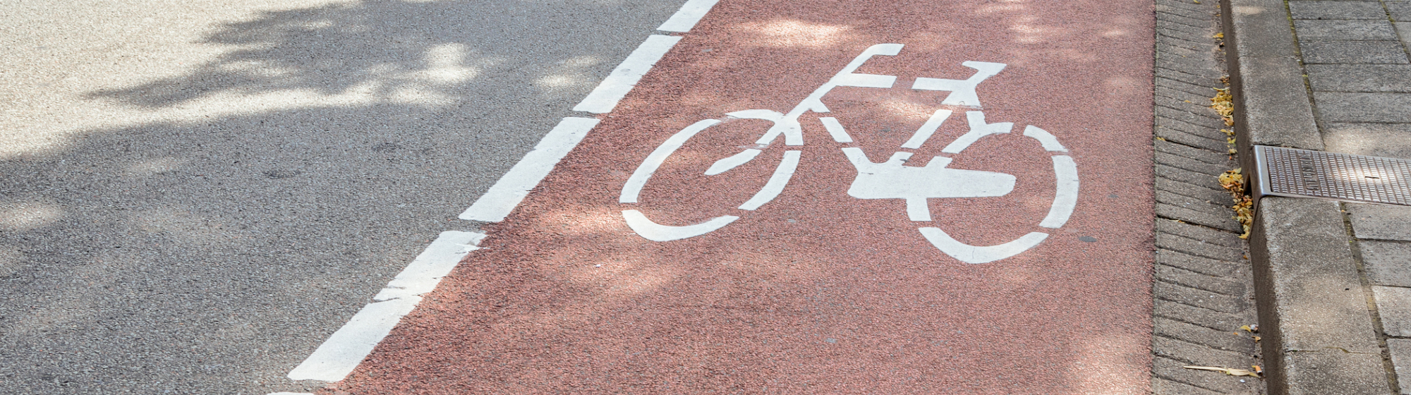 Close-up van een snelfietspad langs een doorgaande weg.