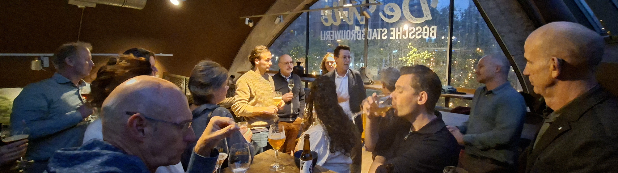 Mensen aan een tafel in een café pratend met elkaar