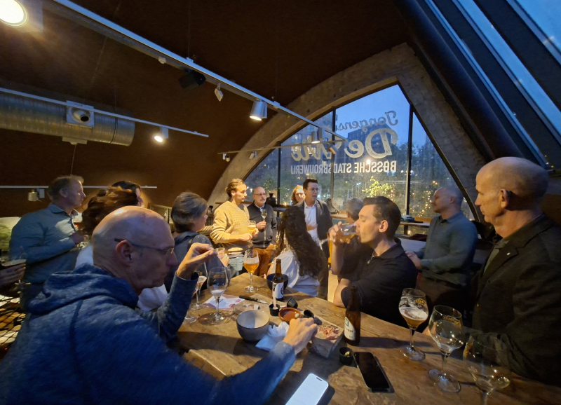 Mensen aan een tafel in een café pratend met elkaar