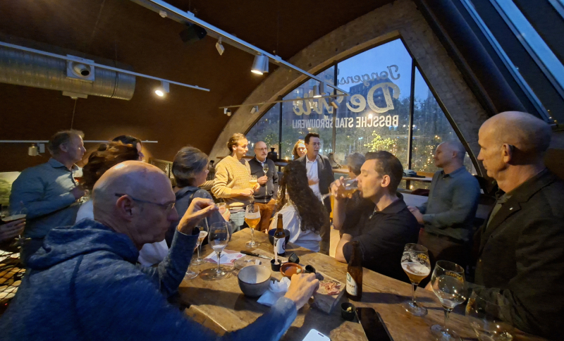Mensen aan een tafel in een café pratend met elkaar