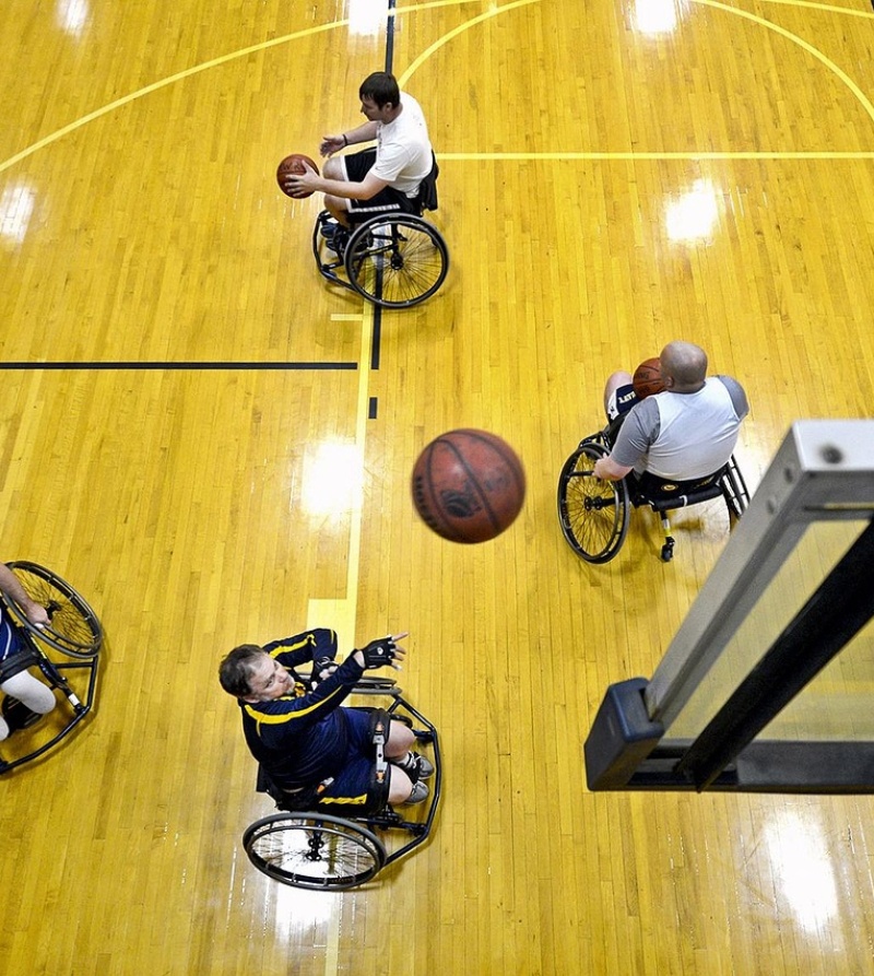 Foto van sporters in een rolstoel die basketbal spelen