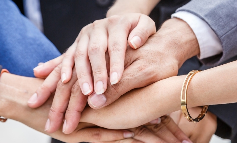 Handen die op elkaar zijn gestapeld