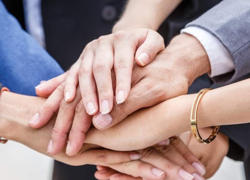Handen die op elkaar zijn gestapeld