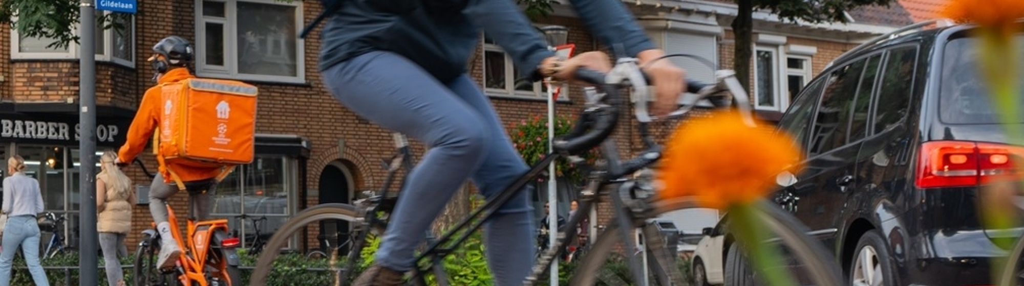 Fietsende dame en thuisbezorger van maaltijden op de fiets