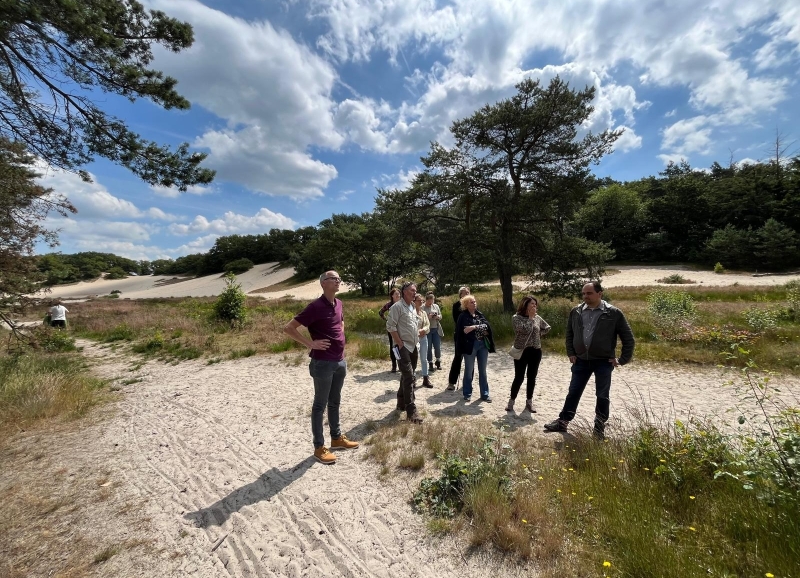Groepje van 9 ambtenaren lopen op een zandpad in de Loonse en Drunense duinen