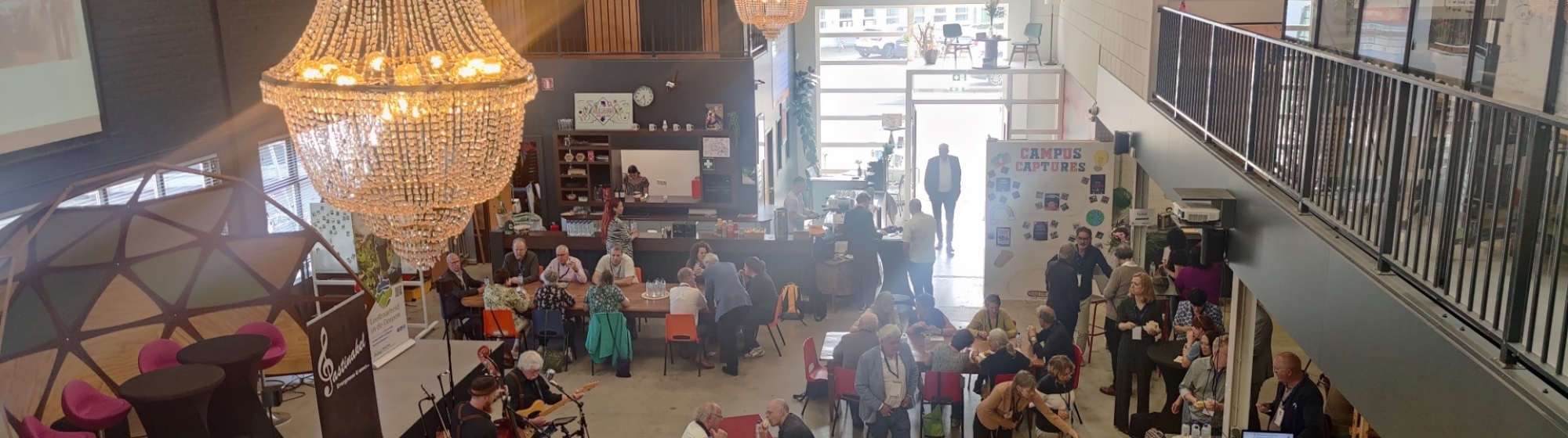 Foto van bovenaf van zaal met bezoekers aan het Leefbaarheidsfestival
