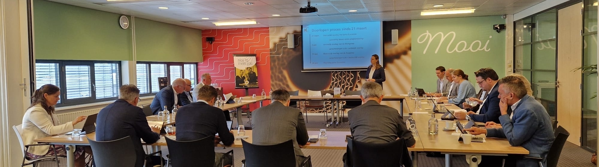 Bestuurders aan tafel in U vorm met elkaar in een overleg tijdens de Regio Dag