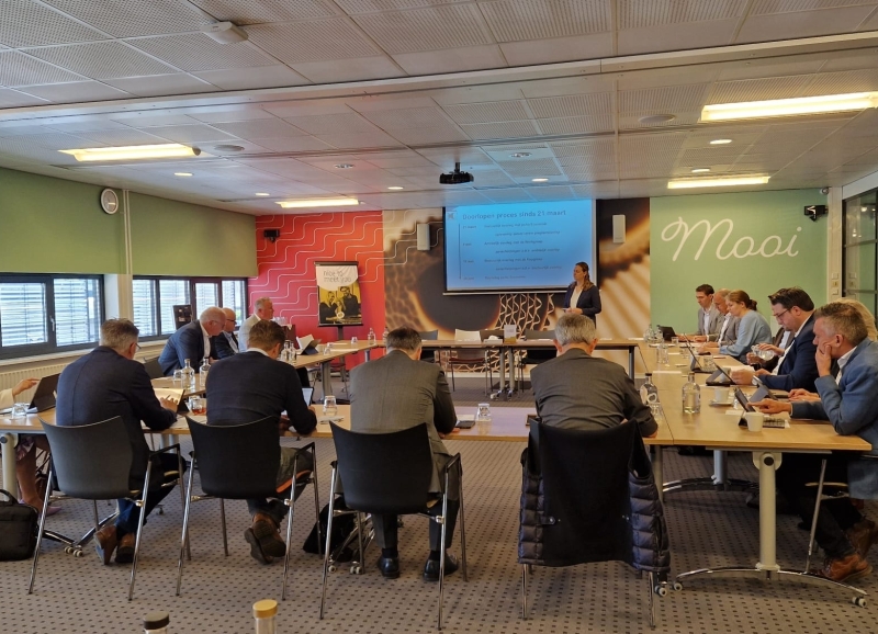 Bestuurders aan tafel in U vorm met elkaar in een overleg tijdens de Regio Dag