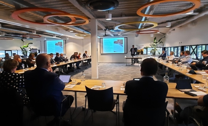 Bestuurders uit de regio zitten aan tafel in een U-vorm