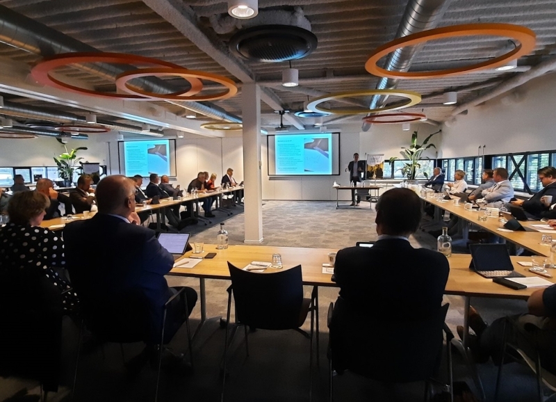 Bestuurders uit de regio zitten aan tafel in een U-vorm