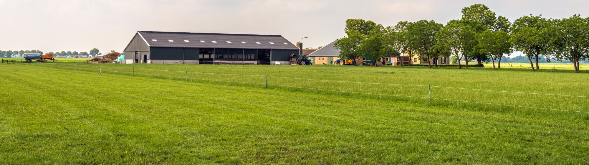 Modern landbouwbedrijf met stal omringd door een groot graslandschap